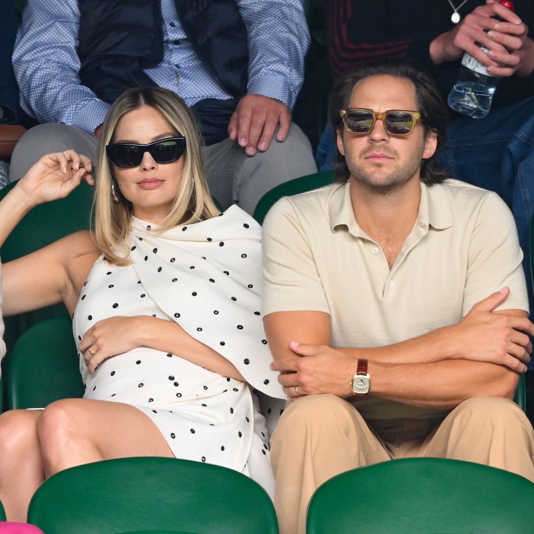 Plano medio de Margot Robbie y Tom Ackerley de público en el Wimbledon 2024